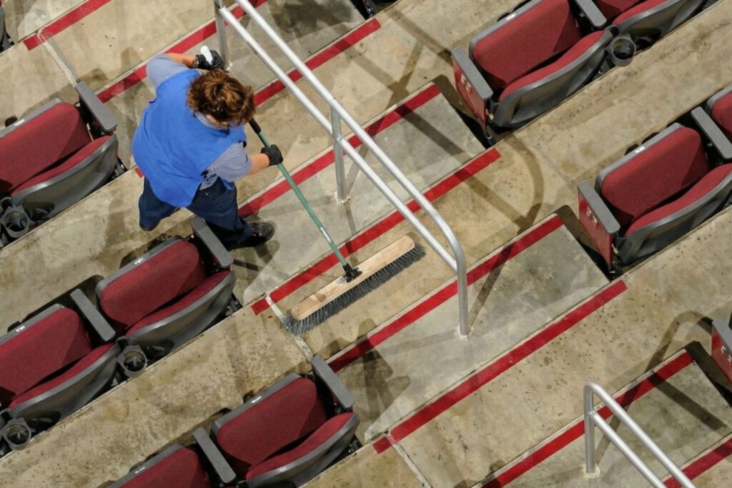 Agent SPN NET nettoyant les gradins d'une salle de spectacle ou cinéma