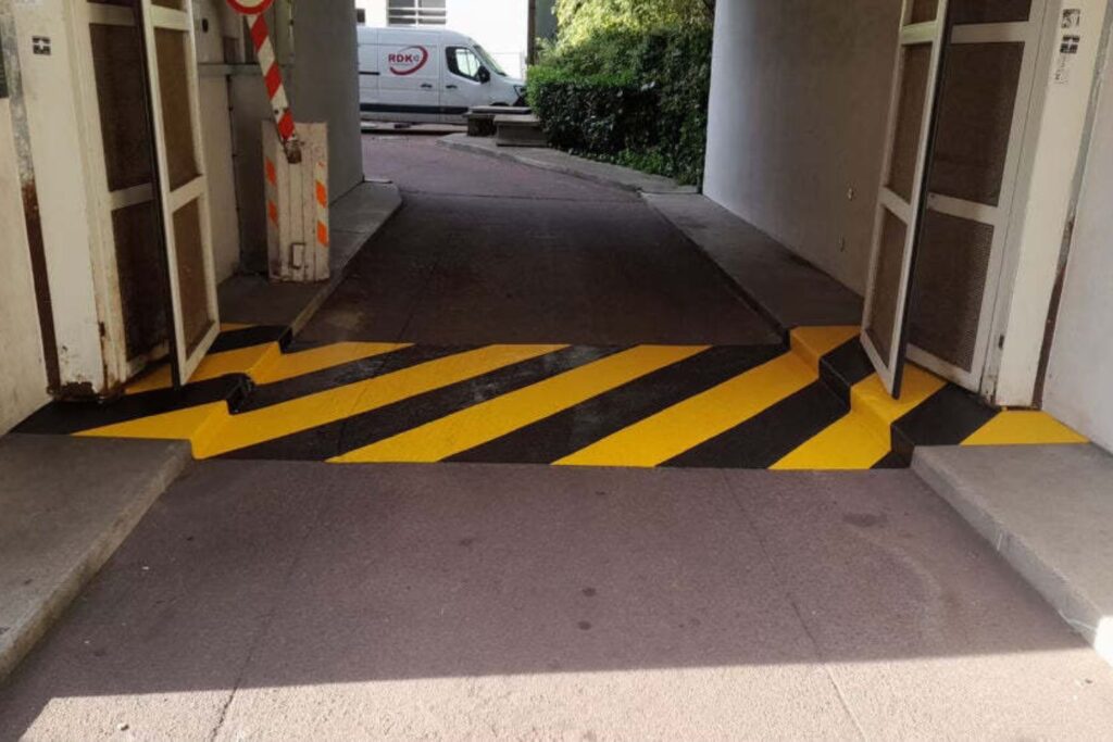 Marquage au sol de sécurité jaune et noir sur rampe d'accès