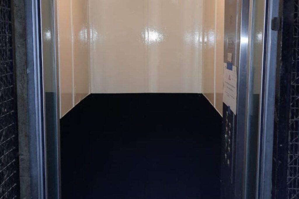Cabine d'ascenseur moderne avec sol noir fraîchement nettoyé